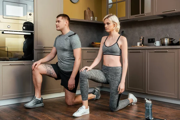 young couple exercising together at home during quarantine