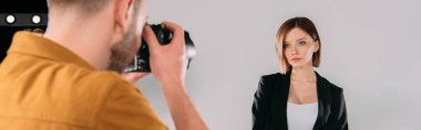Fotoğraf stüdyosunda fotoğrafçıya poz veren güzel bir modelin panoramik görüntüsü.  