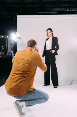 Fotoğraf stüdyosunda şık bir modelle çalışan seçici fotoğrafçı odaklı. 