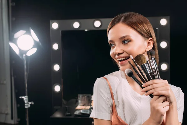 Belle Jeune Mannequin Souriant Tout Tenant Des Pinceaux Cosmétiques Studio — Photo