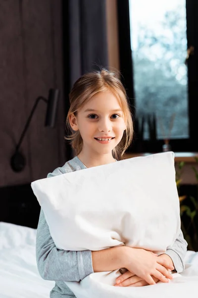 Niño Alegre Sonriendo Mientras Sostiene Almohada Dormitorio —  Fotos de Stock