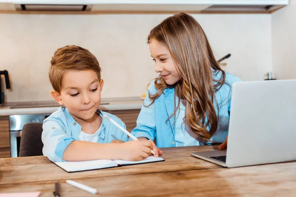 Selective Focus Happy Sister Looking Brother Writing Notebook Laptop While — Stock Photo, Image