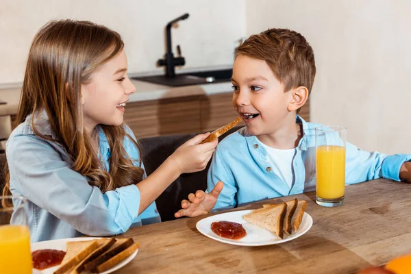 Selektivní Zaměření Šťastné Sestry Krmení Bratra Toast Chlebem Doma — Stock fotografie