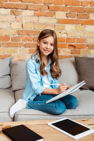 Glad Unge Sitter Soffan Och Skriver Anteckningsbok Nära Digital Tablett — Stockfoto