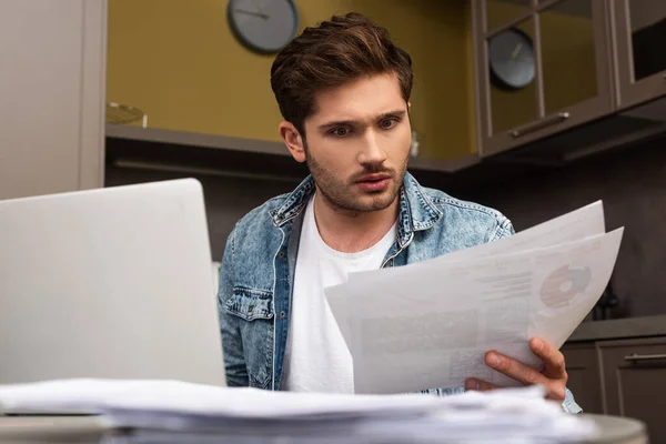 Enfoque Selectivo Del Freelancer Mirando Papeles Cerca Del Portátil Cocina — Foto de Stock