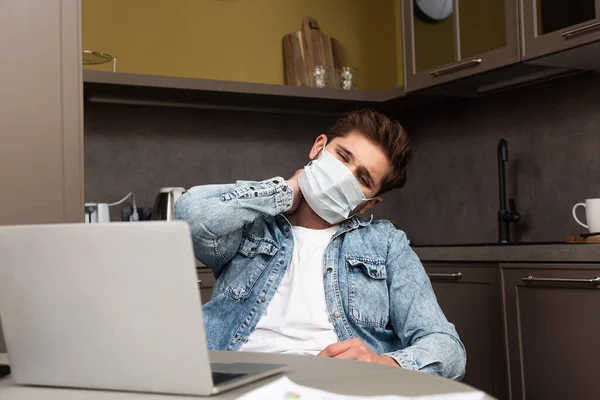 Selective Focus Exhausted Freelancer Medical Mask Sitting Laptop Kitchen Table — Stock Photo, Image