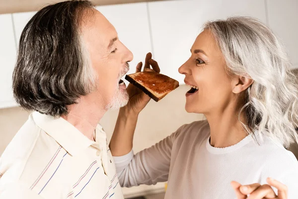 Vista Lateral Pareja Madura Comiendo Pan Tostado Dulce Con Mermelada — Foto de Stock