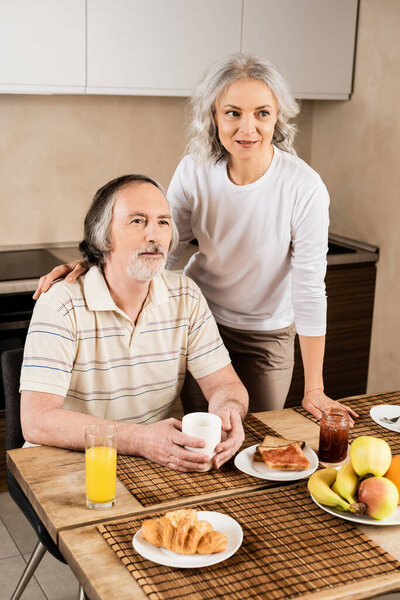 happy mature couple near delicious breakfast 