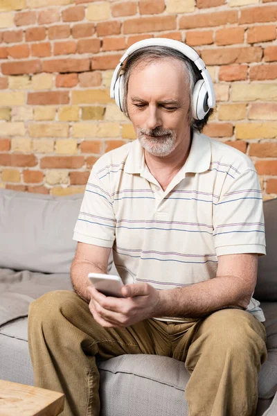 Mature Man Wireless Headphones Using Smartphone Living Room — Stock Photo, Image