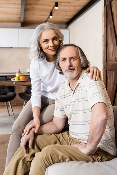 Radosna Kobieta Średnim Wieku Mężczyzna Patrząc Aparat Fotograficzny Salonie — Zdjęcie stockowe