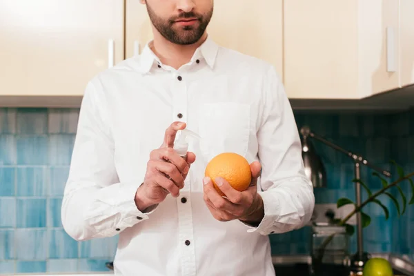 Vista Cortada Homem Desinfetando Laranja Com Desinfetante Mão Cozinha — Fotografia de Stock