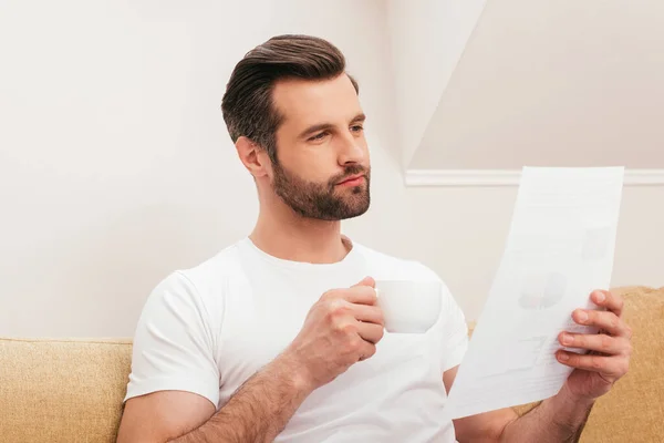 Guapo Teletrabajador Sosteniendo Documento Bebiendo Café Sofá — Foto de Stock