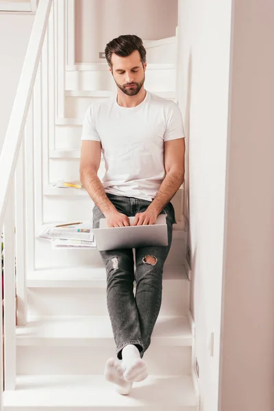 Bonito Teletrabalhador Usando Laptop Perto Papéis Nas Escadas — Fotografia de Stock