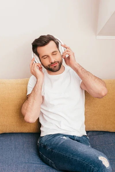 Bonito Homem Ouvindo Música Fones Ouvido Sofá Casa — Fotografia de Stock