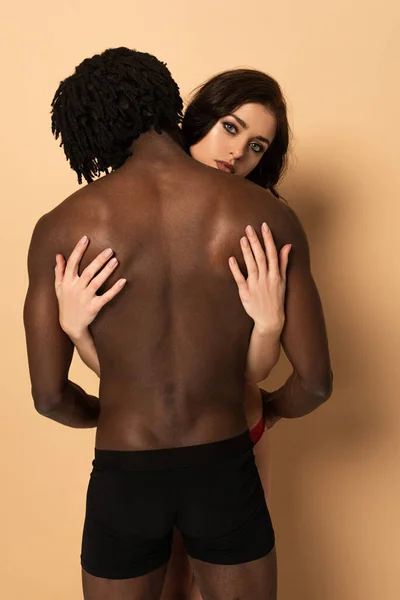 Visão Traseira Casal Interracial Sensual Abraçando Bege — Fotografia de Stock