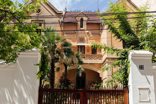 Фасад здания с пальмами и забором в Каталонии, Испания
 