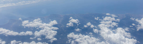 Aerial view of clouds above sea and Catalonia, Spain, panoramic shot 