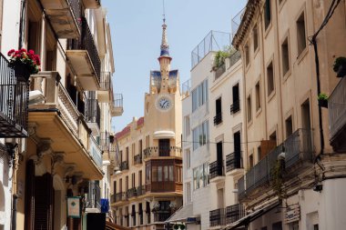 Katalonya, İspanya 'da kilisede saati ve mavi gökyüzü olan şehir caddesi 