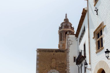 Barselona, İspanya 'da arka planda berrak gökyüzü olan San Bartolome ve Santa Tecla' daki ev ve kilise cephelerinin düşük açılı görüntüsü 