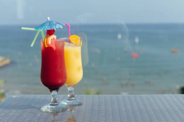 Arka planda mavi gökyüzü ve deniz olan kokteyller. 