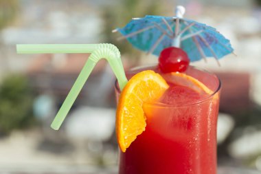 Close up view of glass of cocktail with drinking straws and orange slices  clipart