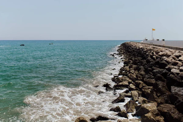 Θαλάσσιο Τοπίο Προβλήτα Και Πέτρες Στον Καθαρό Ουρανό Στο Παρασκήνιο — Φωτογραφία Αρχείου