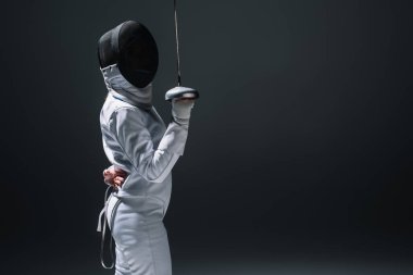 Side view of fencer holding rapier isolated on black with copy space clipart