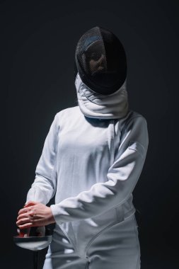 Eskrim kıyafetli ve maskeli eskrimci Rapier 'ı siyah üzerine izole etti. 