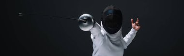 Panoramic orientation of fencer training with rapier isolated on black  clipart