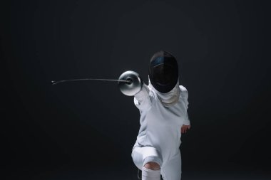 Fencer holding rapier while training isolated on black  clipart