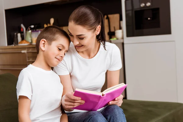 Smiling Mother Holding Book Cute Son Couch — Stock Photo, Image