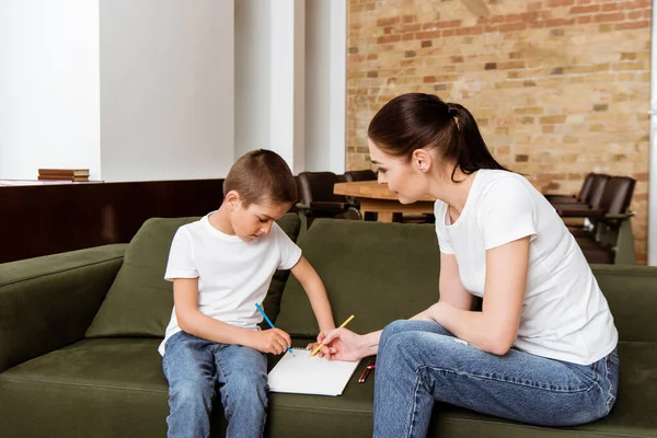 Son Ritning Med Färg Penna Nära Mor Sitter Soffan — Stockfoto