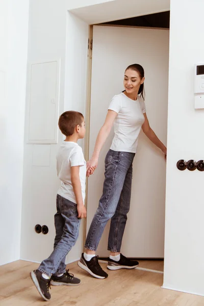 Smiling Mother Kid Holding Hands Open Door Hallway — Stock Photo, Image