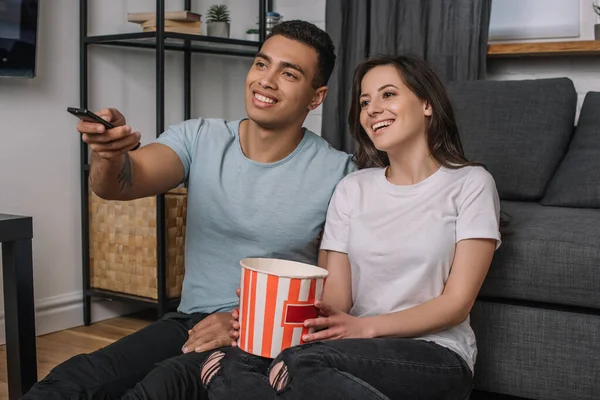 Happy Mixed Race Man Holding Remote Controller Cheerful Girl Popcorn — Stock Photo, Image