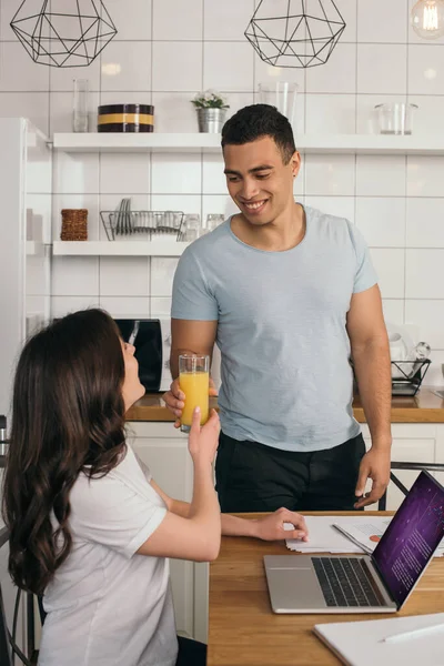 Glücklich Gemischte Rennen Mann Gibt Glas Orangensaft Freundin Der Nähe — Stockfoto