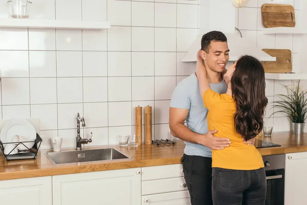 Jovem Mulher Abraçando Namorado Racial Cozinha — Fotografia de Stock