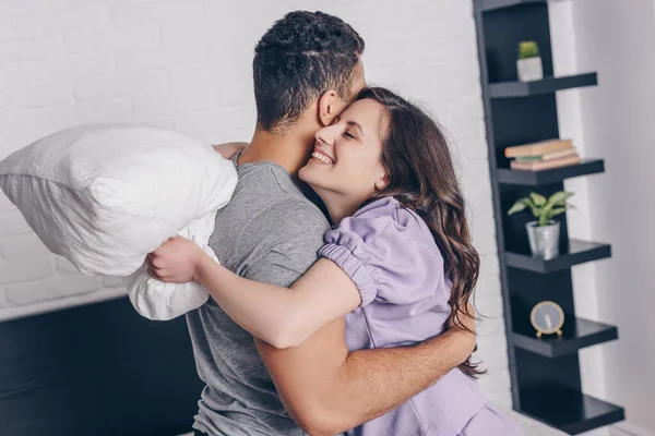 Beautiful Happy Woman Hugging Mixed Race Man While Holding Pillow — Stock Photo, Image
