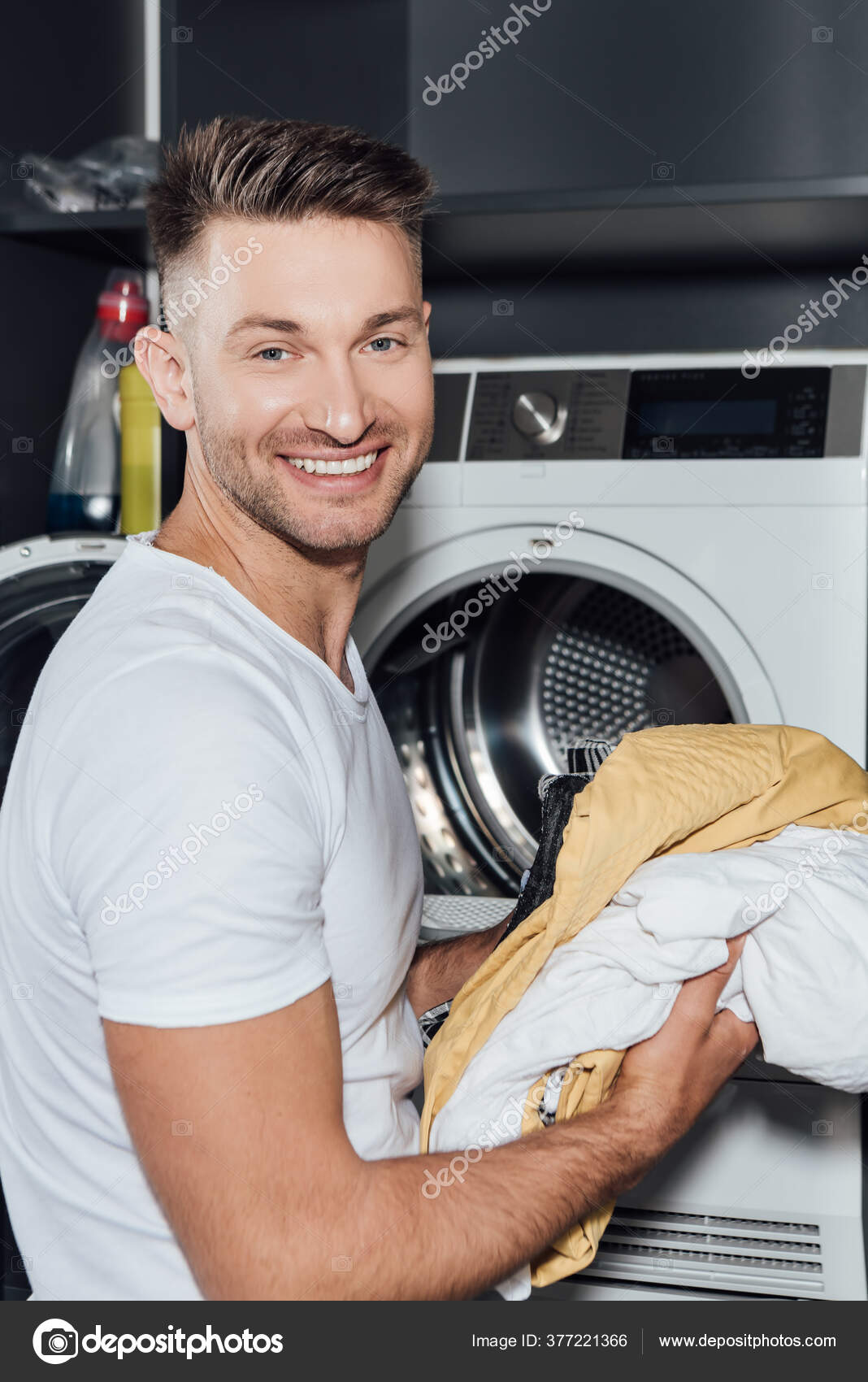 Happy Man Holding Dirty Laundry Washing Machine Stock Photo by