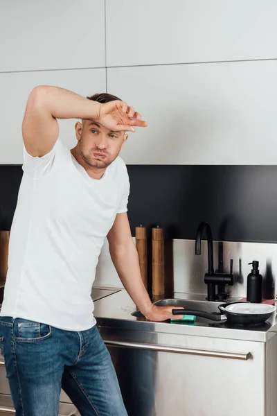 Hombre Cansado Tocando Frente Pie Cerca Placa Húmeda Sartén Cocina — Foto de Stock