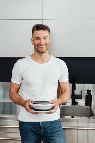 Homem Alegre Bonito Segurando Pratos Limpos — Fotografia de Stock