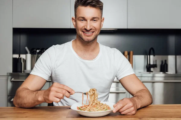 Handsome Man Smiling Camera While Eating Noodles Kitchen — Stock Photo, Image