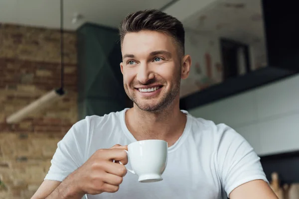 Hombre Guapo Sonriendo Mientras Sostiene Taza Café Casa —  Fotos de Stock