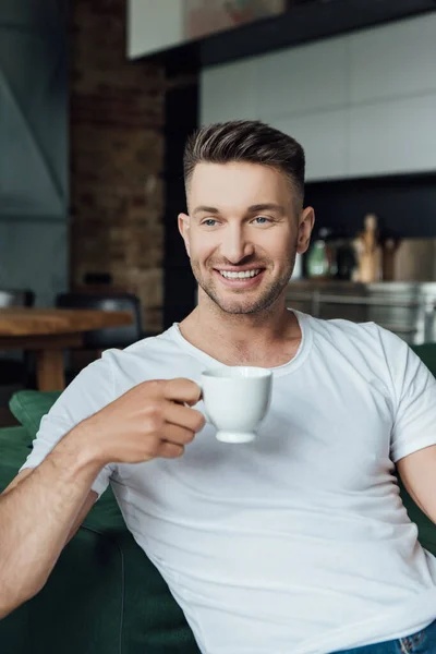 Hombre Alegre Sosteniendo Taza Café Mientras Está Sentado Sofá Sala — Foto de Stock