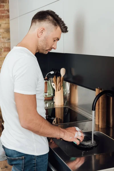 Vista Lateral Homem Bonito Limpeza Frigideira Com Esponja Cozinha — Fotografia de Stock