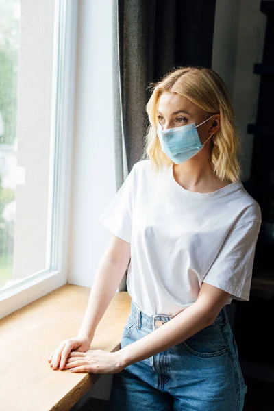 Young Woman Medical Mask Standing Window Home — Stock Photo, Image