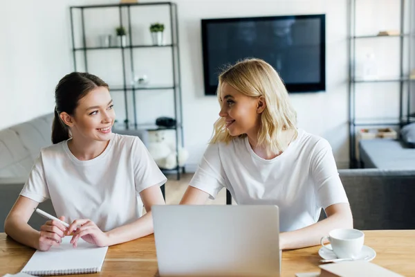 Hermanas Felices Mirándose Uno Otro Cerca Del Ordenador Portátil Portátil —  Fotos de Stock