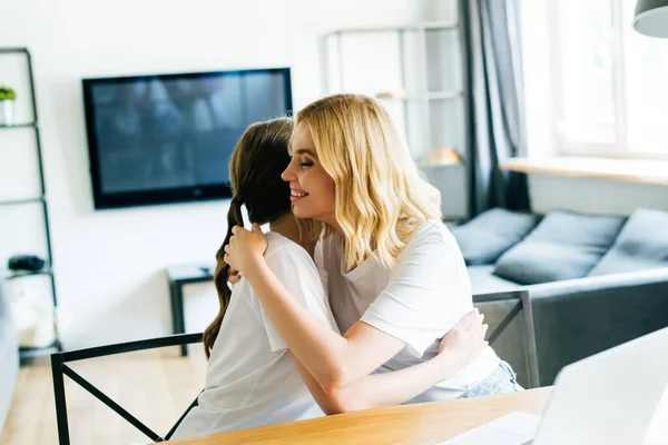 Hermanas Felices Abrazándose Cerca Computadora Portátil Casa —  Fotos de Stock