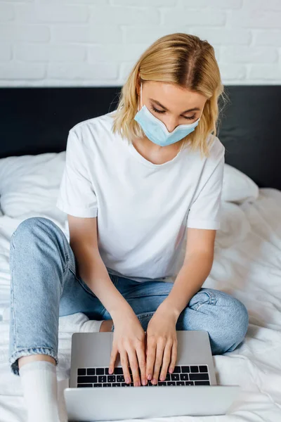 Selective Focus Blonde Girl Medical Mask Using Laptop While Sitting — Stock Photo, Image