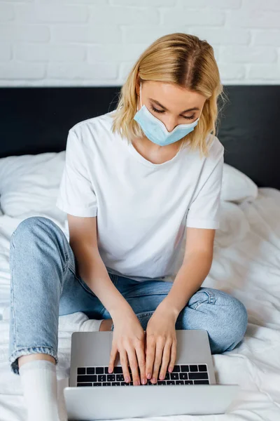 Selektivní Zaměření Blondýny Dívka Lékařské Masce Pomocí Notebooku Při Sezení — Stock fotografie