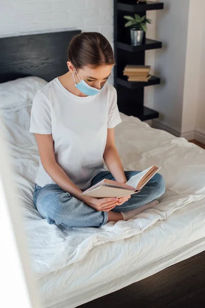 Selectieve Focus Van Jonge Vrouw Medisch Masker Lezen Boek Bed — Stockfoto